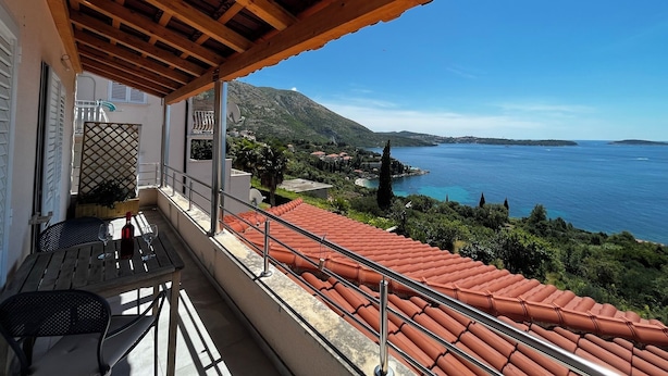 A balcony with a red-tiled roof overlooking a coastal view. - Apartment VITA in Soline near the city of Dubrovnik with a beautiful view (Plat)