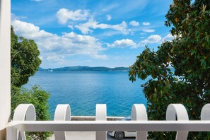 A balcony with a view of a calm sea and distant mountains under a clear sky. - Charming seafront villa Magnolia, 4 * in Bijela, Bay of Kotor / 6 guests (85 343 Bijela)
