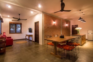 Relax in this inviting space with a dining area, comfortable sofa, and brick accent wall.