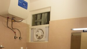 A bathroom with a toilet, sink, and a window above the toilet. - MARINERS CABIN LUXURY HOLIDAY APARTMENT  (Nuwara Eliya)