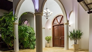A courtyard with stone flooring, white columns, and a wooden door. -  Panoramic Ocean views Waterfront Luxury Home  (Jaco)
