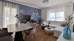 Ett modernt vardagsrum med ett matbord, soffor och en tv.