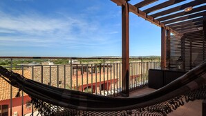 A balcony with a hammock, a view of a cityscape, and a clear sky. - Vilamoura Luxurious PENTHOUSE. 2 large pools, covered parking. (Vilamoura Portugal)
