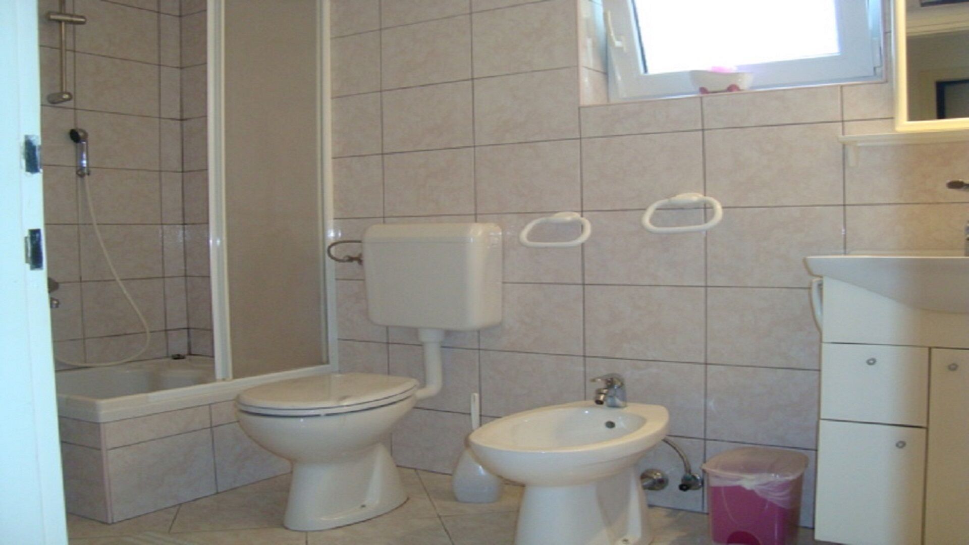 A bathroom with a toilet, bidet, and sink.