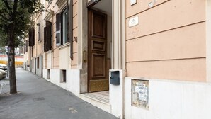 Ein Gebäude mit einer großen Holztür, einem Briefkasten und einem Schild an der Wand.
