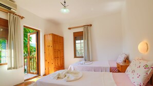 A bedroom with two beds, a wooden wardrobe, a window with curtains, and a ceiling fan. - Kas Holiday Rental with Stunning Sea View and Swimming Pool ( 6 people ) (Turquoise Coast East)