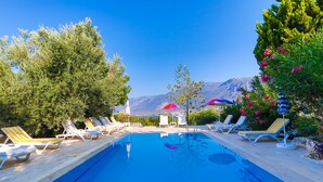 A swimming pool with lounge chairs and umbrellas, surrounded by trees and mountains in the background. - Kas Holiday Rental with Stunning Sea View and Swimming Pool ( 6 people ) (Turquoise Coast East)