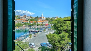 A coastal town with a marina, buildings with red roofs, and a prominent church tower. - Traditional Villa Bonaca in Sumartin with private pool, Brač Island, near sea (Sumartin)
