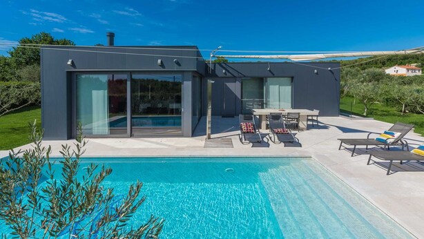 A modern house with a swimming pool, large glass windows, and outdoor furniture. - Villa Lagoderan Rovinj (Rovinj)