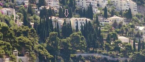 Un quartier résidentiel situé sur la côte, caractérisé par des immeubles à plusieurs étages, une végétation luxuriante et une côte rocheuse.