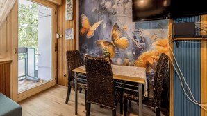 A dining area with a table and chairs, a large butterfly mural on the wall, and a TV mounted above the table. - BUDGET Split City Apartment with 3 Bedrooms, A/C and WI-FI Internet (Split)
