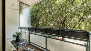A balcony with a view of a tree, a small table with a plant, and a chair. - BUDGET Split City Apartment with 3 Bedrooms, A/C and WI-FI Internet (Split)