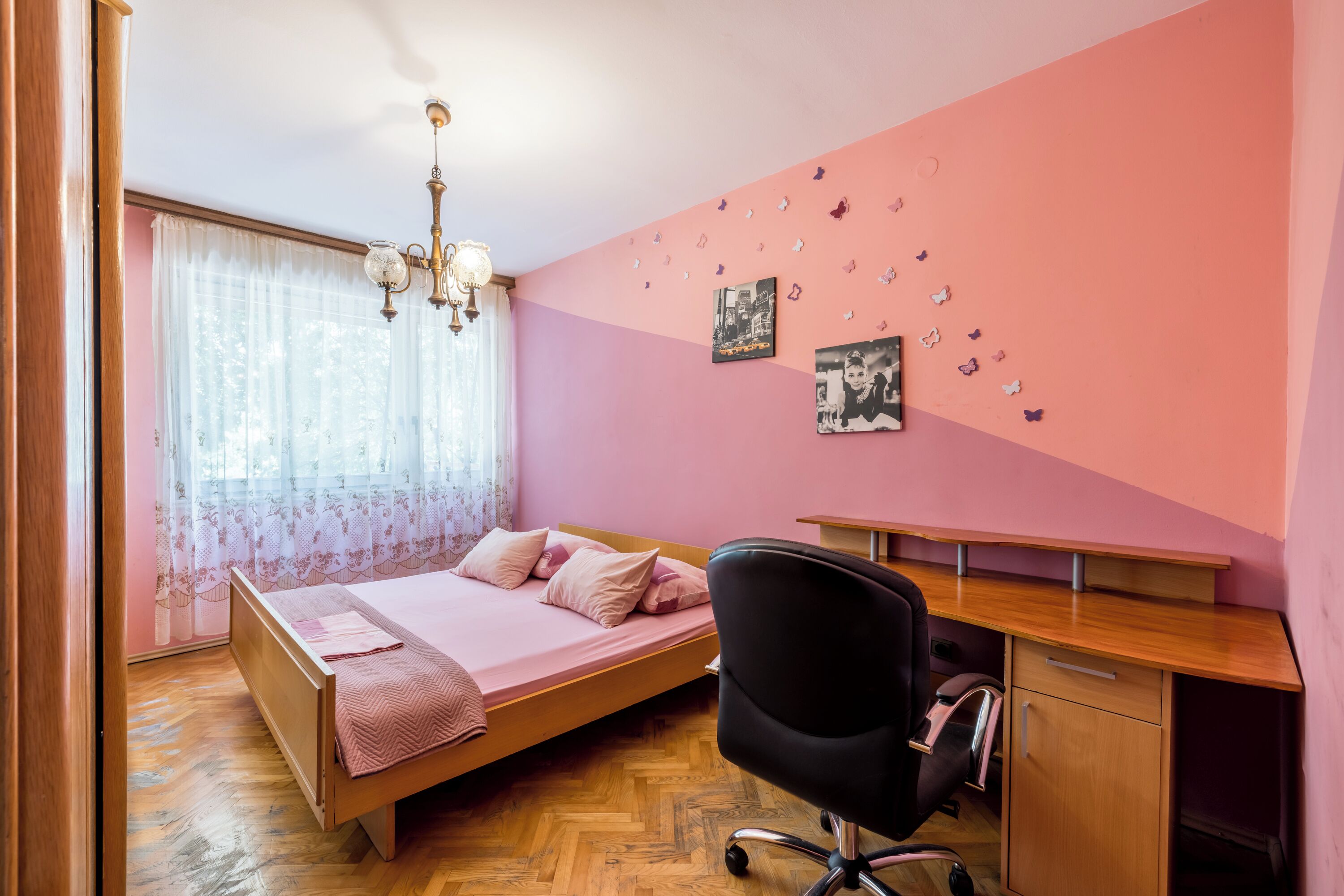 Una camera da letto con un letto, una scrivania e una sedia.
