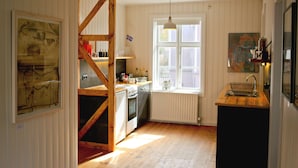 Una cocina con vigas de madera, un ventanal y un lavamanos.