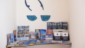 A display of travel brochures and books on a table with a wall art piece above. - Libeccio - flat with terrace & sea view, perfect for up to 3 guests (Maiori)