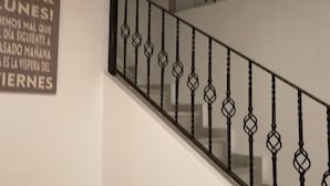Una scala con ringhiera in metallo e una insegna appesa al muro.