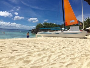 Une plage de sable où un voilier est amarré près du rivage.
