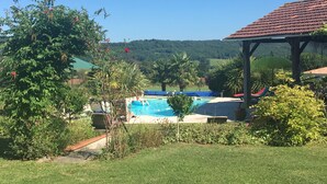 Ein Poolbereich mit freiem Blick auf die umliegende Landschaft, darunter Bäume und eine entfernte Hügelkette.