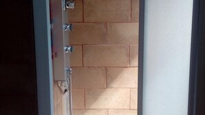 Une salle de bain avec une douche, un miroir et un porte-serviettes.
