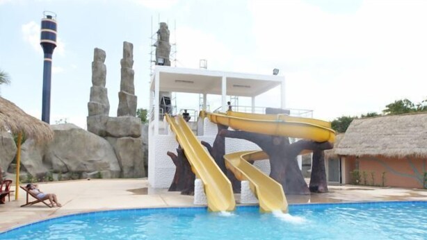 Un parc aquatique comprenant une piscine, deux toboggans et un poste de surveillance pour les sauveteurs.