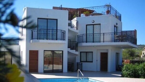 Un edificio moderno de dos plantas con una piscina delantera.