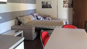 A bedroom with a bed, a small table, a chair, and a wardrobe. - Sirmione Borgo Rosa, your holiday flat. Wifi. (Sirmione)