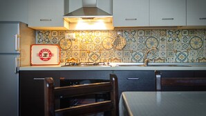 A kitchen with a tiled backsplash, a gas stove, and a coffee shop sign. - Bice's House - Accommodation 3 (Cassibile)