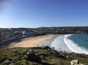 Une ville côtière avec une plage, une côte rocheuse et des bâtiments en arrière-plan.