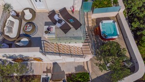 Vista aérea de una terraza en la azotea con mobiliario exterior, una bañera de hidromasaje y una piscina.