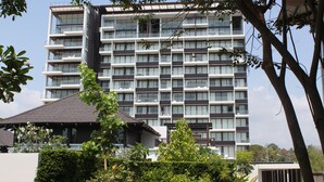 A multi-story building with a modern architectural design, featuring a series of balconies and large windows. - Luxury apartment with beautiful sea view and large terrace (Klaeng District)