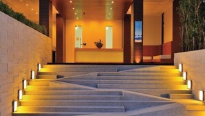 A staircase leading to a reception area with a reception desk, a potted plant, and a view of the outdoors. - Luxury apartment with beautiful sea view and large terrace (Klaeng District)