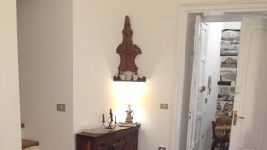 Une pièce avec un sol à carreaux, un meuble en bois, une table avec une chaise et un canapé rouge.