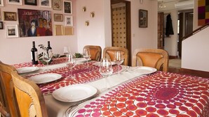 Un coin repas avec une table dressée pour quatre personnes, entourée de chaises.