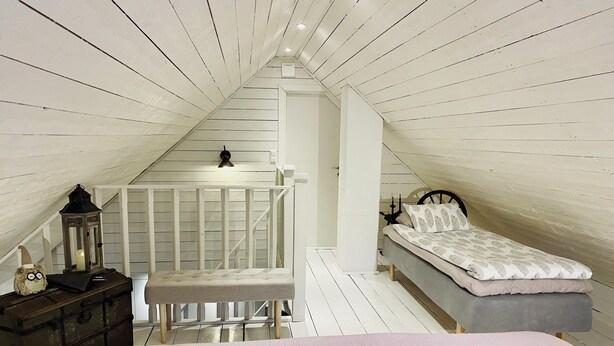 A bedroom with a loft bed, a nightstand, a dresser, and a decorative lantern. - "Slamrekullen" our place in Ullared - Sweden (Ullared)