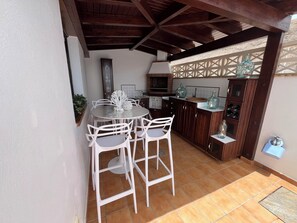 A kitchen with a round table, white chairs, and wooden cabinets. - ABSOLUTE TRANQUILITY, COMFORTABLE AND CENTRAL LOCATION. (Tuineje)
