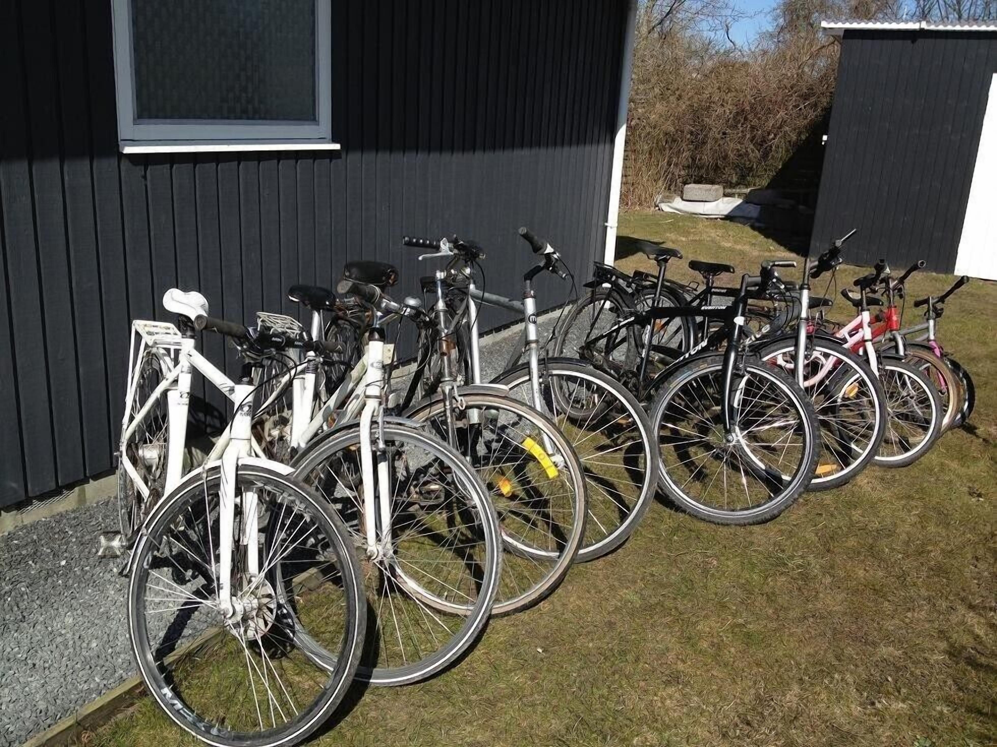 Bicycles parked in front of a building with a window and a door.