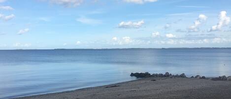 A beach with a rocky shoreline and calm water.
