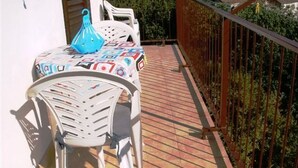 A balcony with a table and chairs, a blue vase, and a patterned tablecloth. - Apartment for 4 persons in Jelsa on the island Hvar (Jelsa)