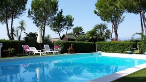 Una piscina con lettini e vista sulla spiaggia.
