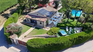 Vista aerea di una proprietà con piscina, vasca idromassaggio e giardino curato.