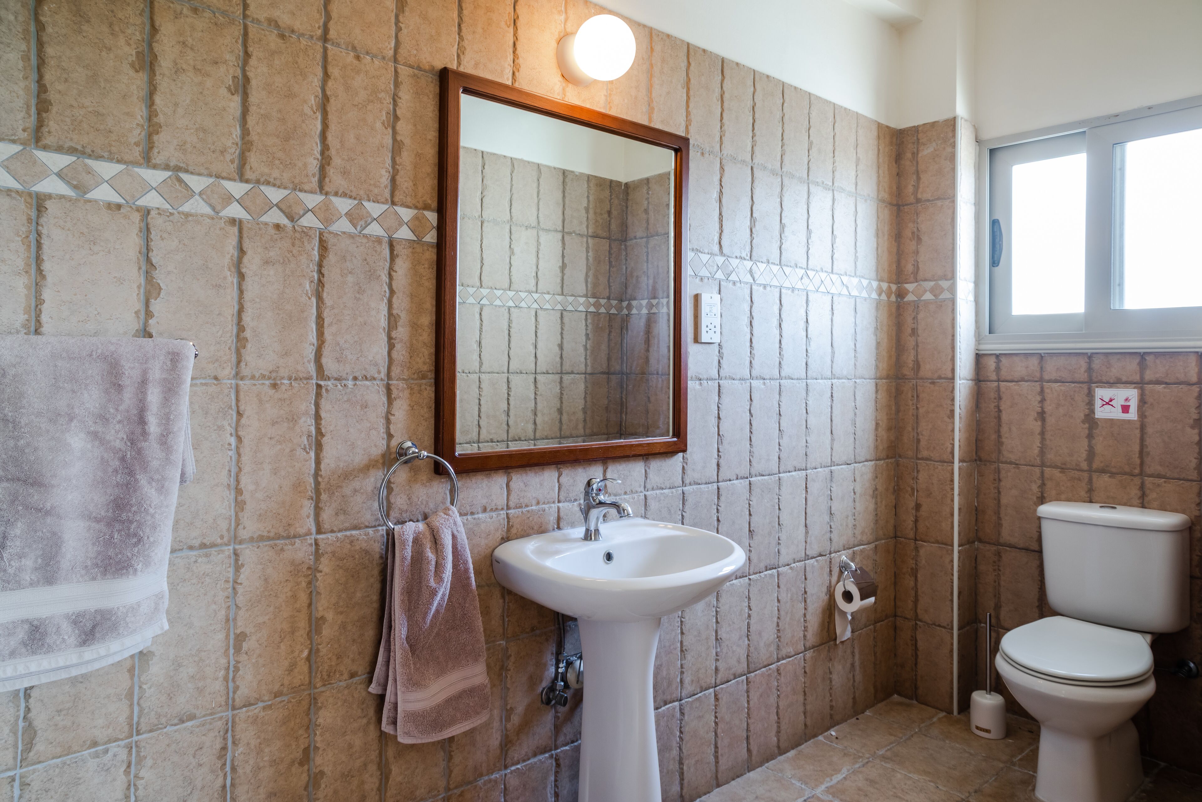 A bathroom with a sink, mirror, and toilet.
