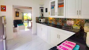 A modern kitchen with white cabinets, a black countertop, and a colorful backsplash. - ⭐⭐⭐⭐⭐Villa 4 bedrooms with private pool 5 minutes beaches and Walking Street. (pattaya)