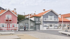 A street with traditional buildings, a paved area, and a person walking.