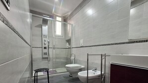 A modern bathroom with a glass shower enclosure, a toilet, and a sink. - HOLIDAY HOME Central Station, Business Center, Naples city center, Mary's Room (Napoli)