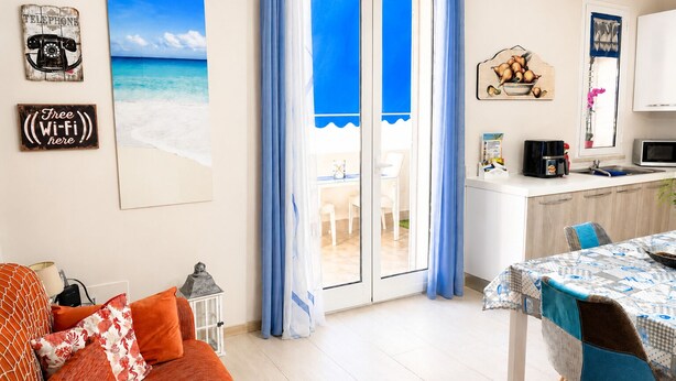 Ein Zimmer mit Blick auf den Strand, einem Essbereich und einer Küche.