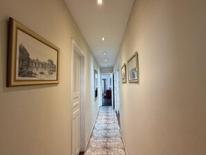 A hallway with framed pictures on the walls, a tiled floor, and a door at the end. - PENTHOUSE BOTAFOGO Panoramic penthouse with large terrace in Rio de Janeiro (Rio de Janeiro)