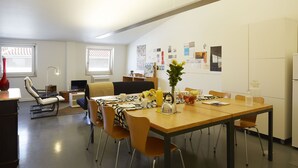 Una sala de estar moderna con comedor, que incluye un sofá, un televisor y una mesa de centro.