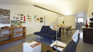 Una sala de estar moderna con un sofá, una mesa de comedor y una zona de cocina.