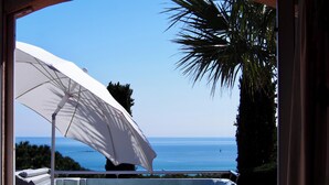 A hot tub with a white umbrella, overlooking a clear blue sea and a distant ship on the horizon. - Gorgeous sea view, heated pool, jacuzzi, sauna, close to the beach. (Sainte-Maxime)