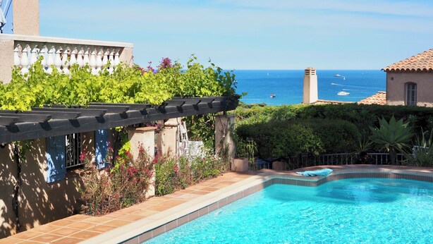 A swimming pool with a view of the sea, surrounded by greenery and a pergola. - Gorgeous sea view, heated pool, jacuzzi, sauna, close to the beach. (Sainte-Maxime)